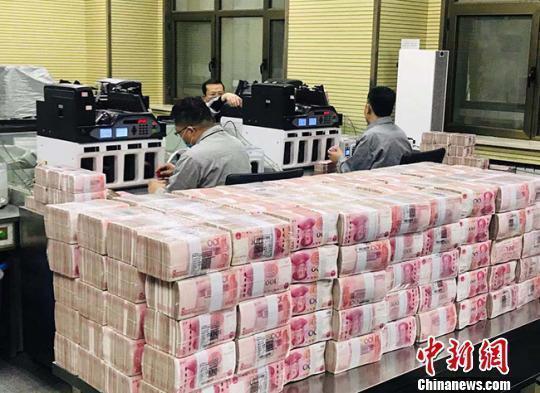 资料图:银行点钞员在工作。艾庆龙 摄