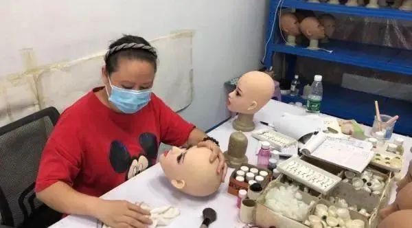 ▲工人正在为娃娃头部化妆