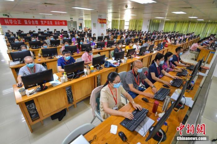 资料图:7月17日,评卷教师们佩戴口罩在位于海南师范大学的海南高考评卷现场工作。 中新社记者 骆云飞 摄
