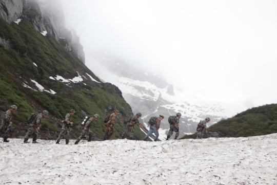 官兵们巡逻在雪山上。