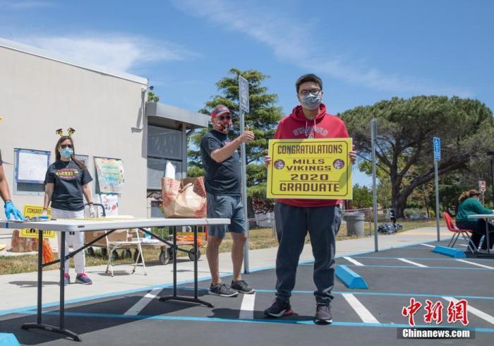 资料图:当地时间5月15日,美国北加州圣马特奥县的米尔斯高中迎来特殊毕业季,毕业生们开车或乘车来到学校工作人员布置的不同站点,完成还书、缴费以及领取毕业物品等环节,学生全程与工作人员没有直接接触。