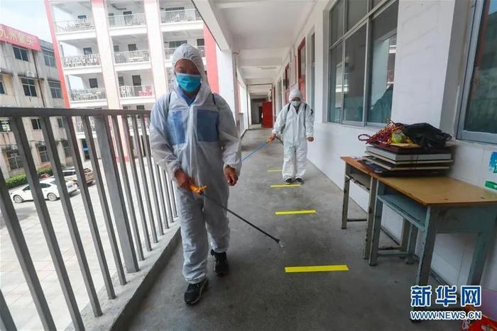 ▲7月6日,工作人员在河南省信阳市光山县第二高级中学走廊进行消杀防疫。新华社发(谢万柏 摄)