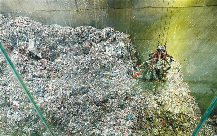海口生活垃圾焚烧发电厂的一间垃圾库内,机械手臂正在抓取垃圾。 海南日报记者苏晓杰摄
