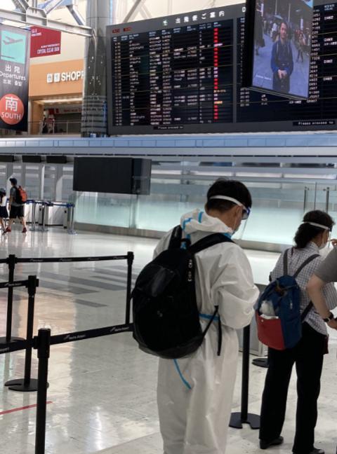 成田机场,中国乘客身着白色防护服 图源:西日本新闻