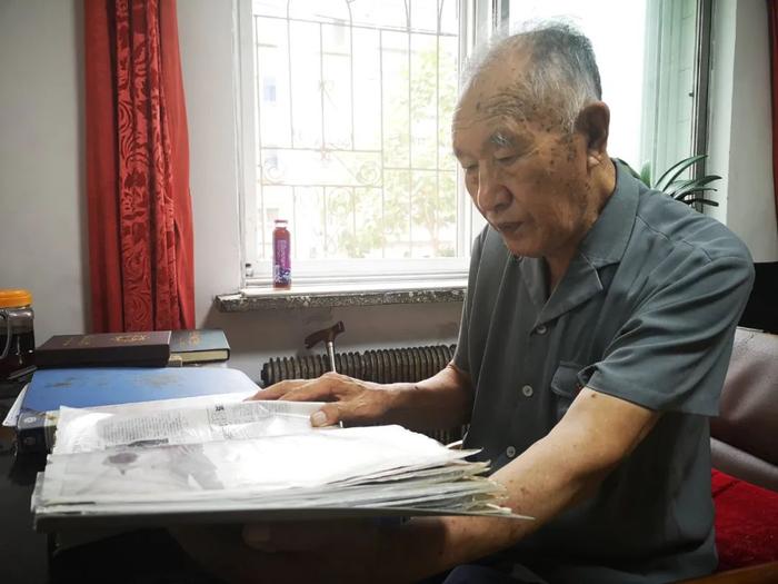 ▲7月30日,李相玉在家中翻阅个人剪报资料。(王莹 摄)