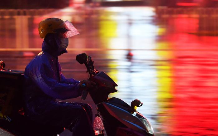 2020年8月12日晚,在雨中送外卖的骑手。新京报记者 李木易 摄