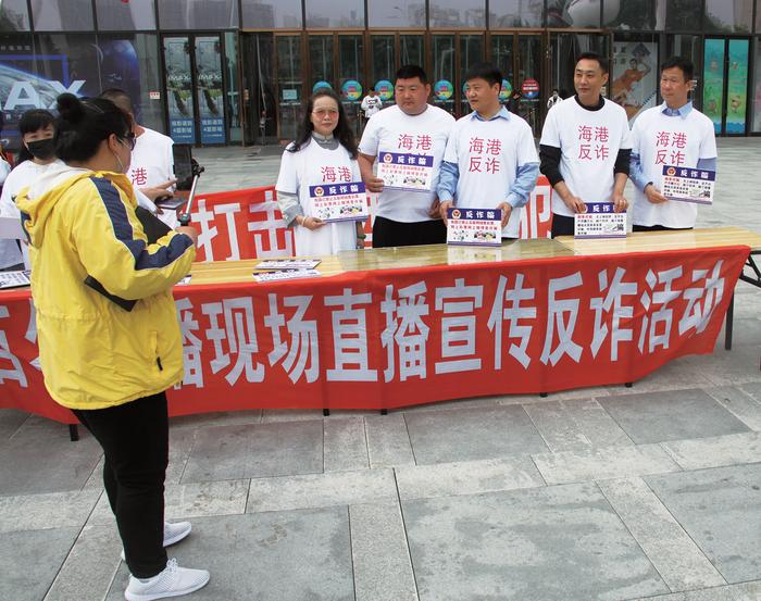 陈国平(右三)与同事在商业综合体门口进行反诈宣传。资料图片/秦皇岛市公安局海港分局供图