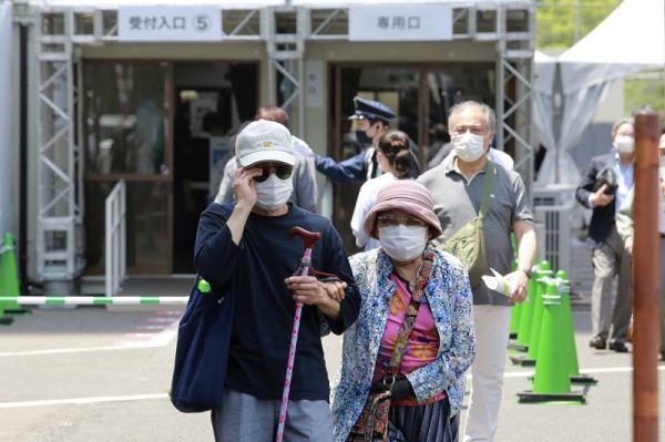 资料图片:人们接种新冠疫苗后走出日本东京一处接种中心。 (彩色通稿,新华社/美联)