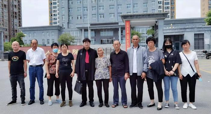 ▲2020年8月,周兆成律师与被害人家属在泌阳县人民法院门口合照。受访者供图
