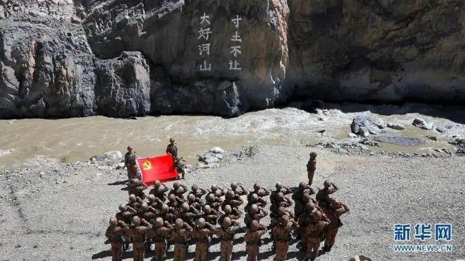某边防团官兵在“大好河山 寸土不让”标语前举行重温入党誓词仪式(资料照片)。新华社发(郑晓林 摄)