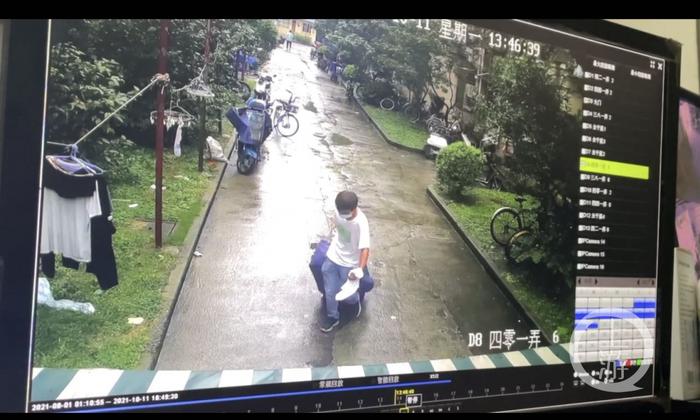 ▲网传视频中,一男子拉着行李箱离开案发小区。图片来源/视频截图
