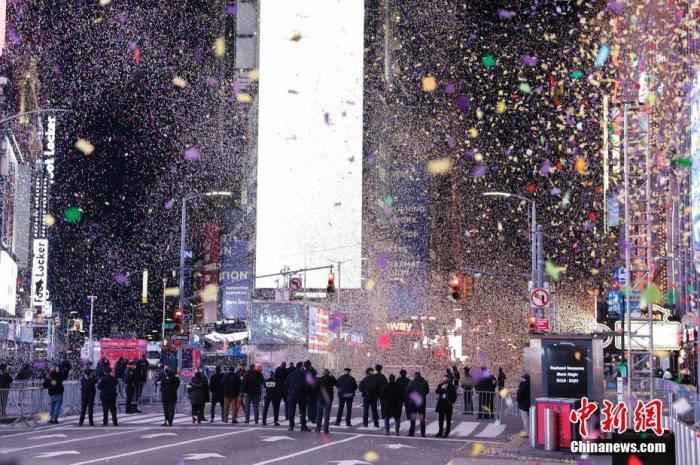 资料图:当地时间2021年1月1日0时,新年钟声敲响,纽约时报广场焰火燃放,彩纸飞舞,庆祝新年到来,警察等人员在空旷的广场上执勤。