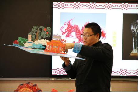 济南市级非遗项目济南剪纸代表性传承人王涛为学生展示作品。济南市文化和旅游局 供图