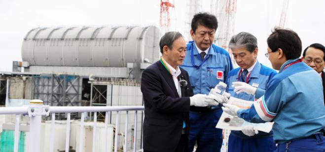图为日首相菅义伟2020年9日在福岛第一核电站视察时,被告知核污水稀释后可以喝。但他最终没有饮用。图片来源:日本《朝日新闻》