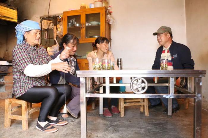 资料图片:倪明真(右一)在与群众交流。新华社发