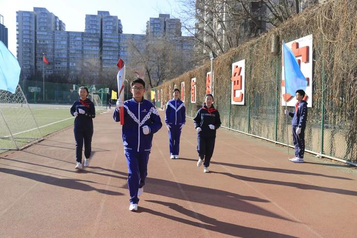 接过校长的冬奥火炬，广渠门中学学生“火炬接力”迎接新学期