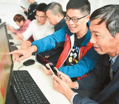 ▲江苏大学志愿者在帮助老年人学习网上购物技能。石玉成摄(人民图片)