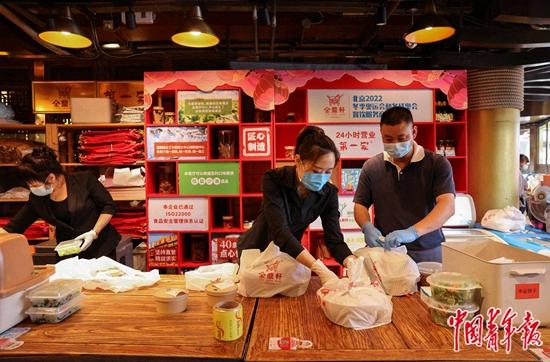 6月6日,北京市东城区一家餐厅内,店员在打包外卖。当日,除丰台区全域及昌平区部分区域外,北京全市其他地区餐饮经营单位开放堂食服务。根据防疫要求,各餐饮经营单位需控制人流密度,合理保持就餐间距,提倡隔位就座、打包外卖、使用移动支付等无接触方式结算。中青报·中青网记者 曲俊燕/摄