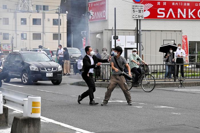 7月8日,日本奈良市,安倍保镖试图捕捉一名疑似向安倍晋三开枪的男子(右)。 人民视觉 图