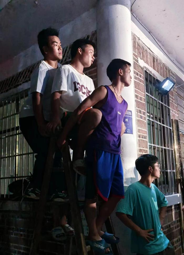 站在梯子上观赛的村民。 澎湃新闻记者 胡杰 图