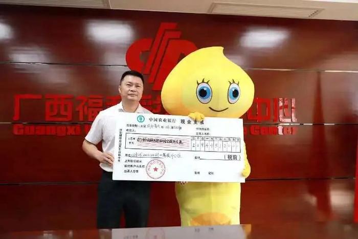 广西福彩中心党总支部书记、主任蓝挺将现金支票交给大奖得主(右)