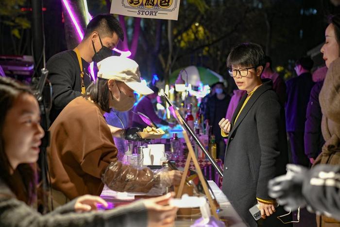 2月28日,在四川省成都市锦江区三色路夜市,市民在购买小吃。新华社记者 唐文豪 摄