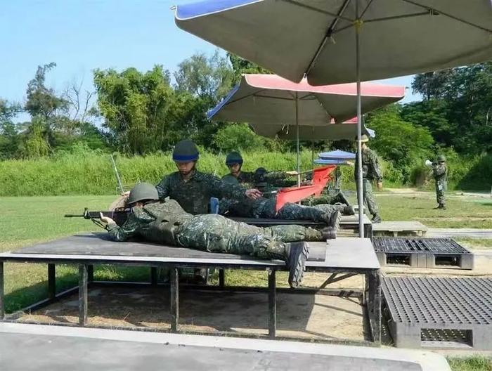 台兵在太阳伞下训练射击