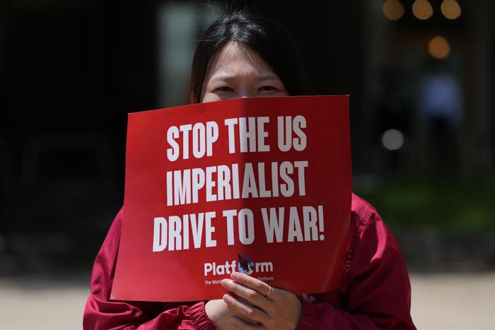 5月21日,一位抗议者在日本广岛袋町公园手举抗议七国集团峰会的标语。新华社记者张笑宇摄