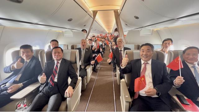 首航成功后,四位“首排乘客”纷纷伸出大拇指为C919点赞。 澎湃新闻记者 赵昀 摄