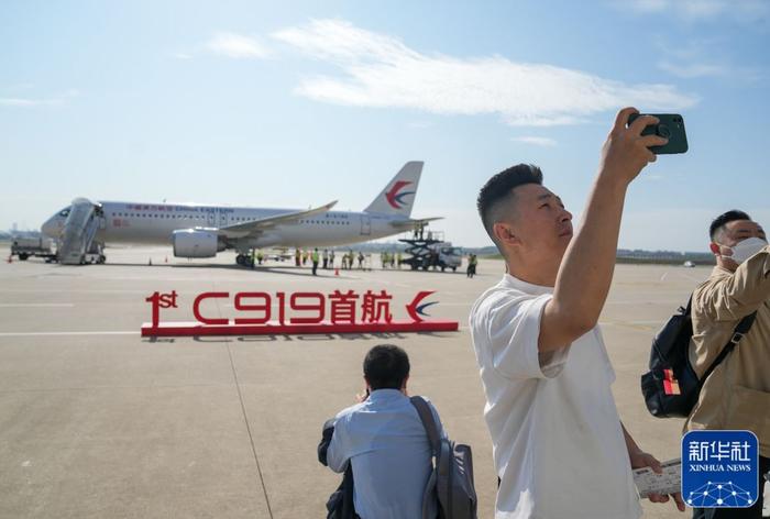 5月28日,旅客与即将首航的C919飞机合影。新华社记者丁汀摄