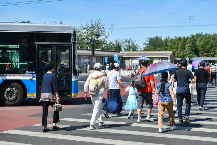 6月4日，在天坛路体育馆路路口。一辆右转的公交车在斑马线前等待行人通过。 邓伟摄