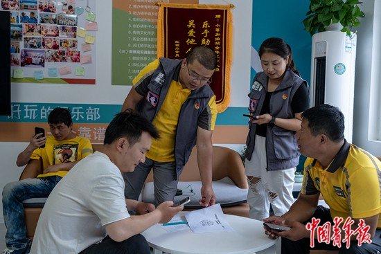 9月5日,北京市朝阳区费家村“小哥加油站”,董婉秋(右二)、常凯(右三)邀请付丛荣(右一)填写需求调查问卷。