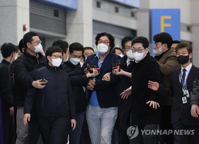 2023年1月17日,韩国仁川国际机场,“双铃案”核心人物、双铃集团前任会长金圣泰(音译,居中)被押送回韩国。图片来源:韩联社
