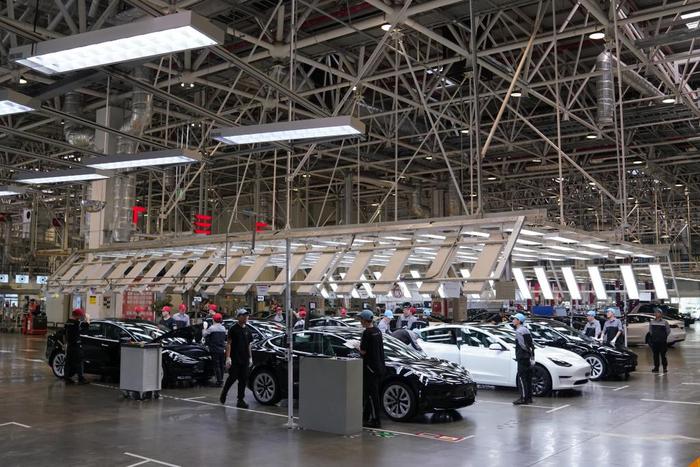 2023年5月12日,在特斯拉上海超級工廠總裝車間,工人對車輛進行檢測。新華社記者 馬寧 攝