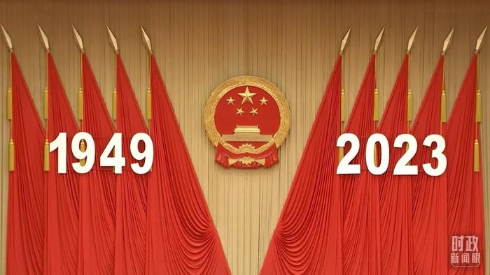 △人民大会堂宴会厅内,主席台上方高悬着庄严的国徽,“1949-2023”大字年号在鲜艳的红旗映衬下格外醒目。