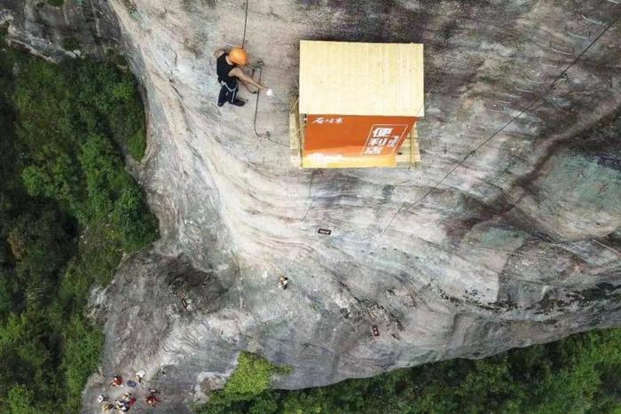 湖南一景区在悬崖壁上建便利店：为攀岩者设立，人工背水