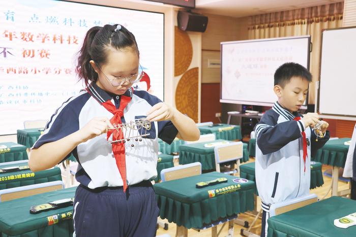 ▲南宁市华西路小学学生进行九连环比赛。(韦晓夏 摄)