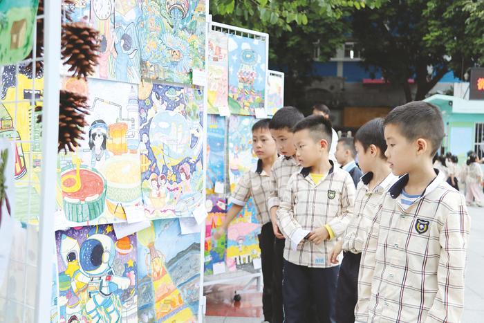▲南宁市民族大道东段小学学生在参观科幻画展。(杨艳 摄)