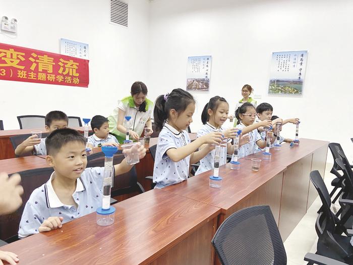 ▲南宁市园湖路小学学生做净水实验,探寻污水变清流的奥秘。 (覃侣冰 摄)
