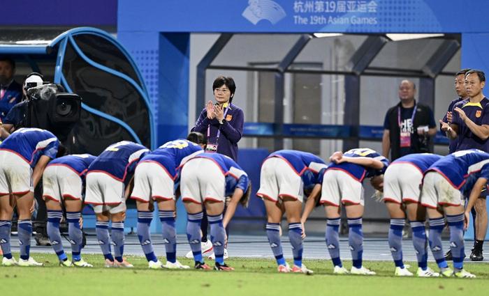 亚运会半决赛不敌日本队后,日本女足球员向水庆霞鞠躬。