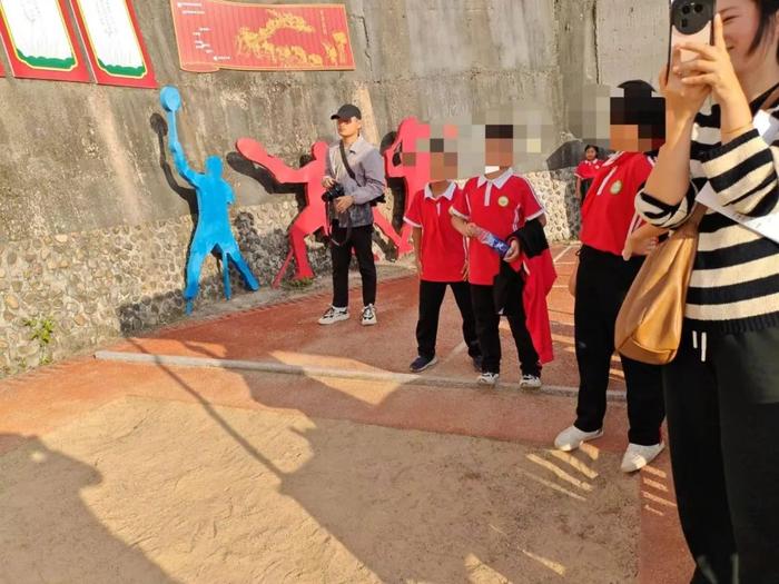▲课间活动,小学生们在沙堆旁玩耍。受访者供图