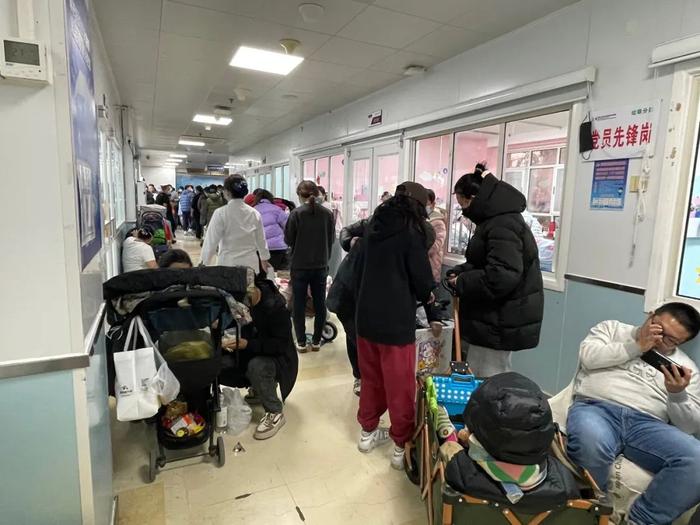 11月26日，首都儿科研究所附属儿童医院输液室走廊上，家长使用露营车等工具让孩子休息。新京报记者 周思雅 摄