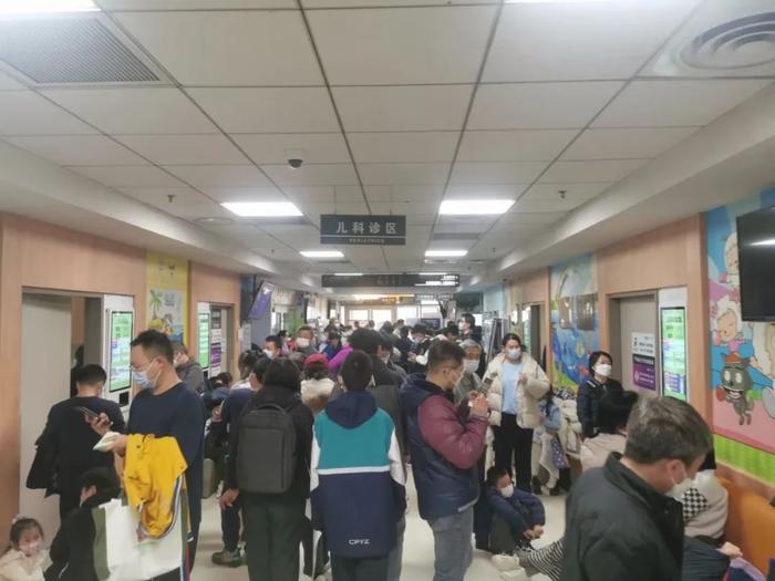 清华大学附属北京清华长庚医院儿科诊室外候诊的家长患儿排起长队。受访者供图
