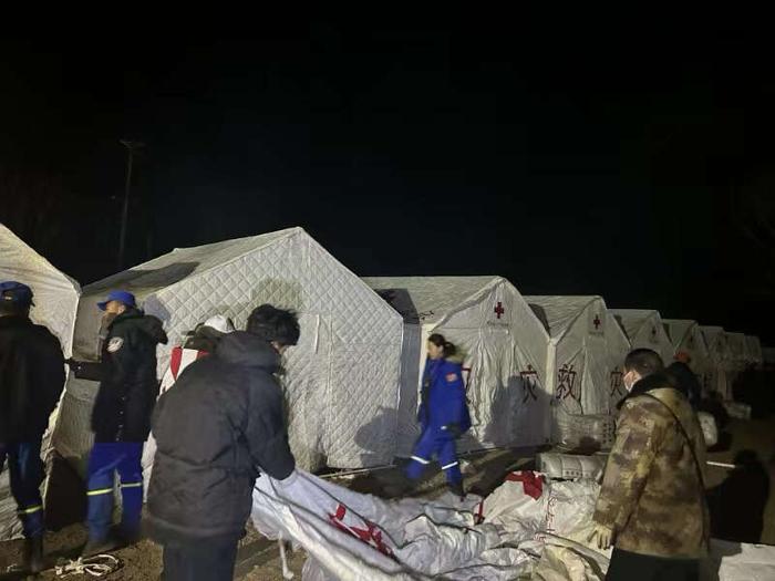 12月19日晚，青海海东金田村。工作人员正搭建安置群众的帐篷。