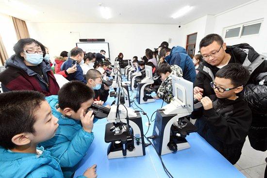 1月19日,哈尔滨医科大学校园开放,游客在医学形态学实验室通过显微镜观察人体的奥秘。