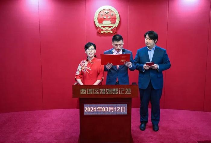 3月12日,新人张女士和王先生在工作人员的帮助下进行结婚宣誓。图片来源:新华社