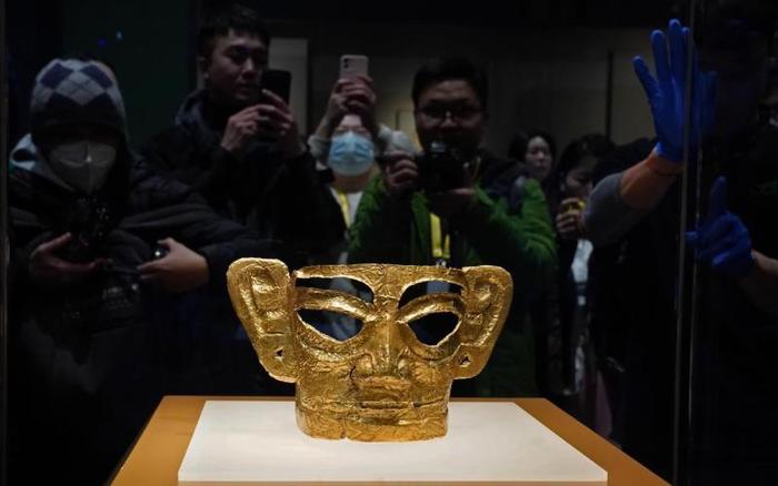 ▲1月29日,三星堆遗址出土的文物——金面具和竖披发青铜人像在上海博物馆东馆特展厅内开箱。图/新华社