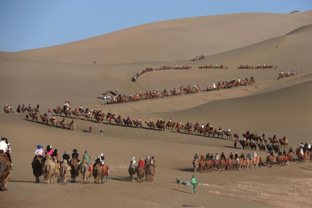 甘肃敦煌：月牙泉景区人流如织 游人骑骆驼赏大漠风光