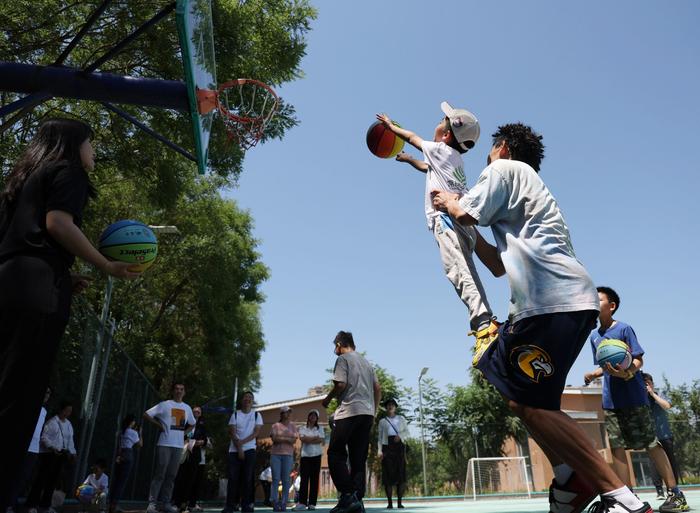 姚基金为儿童村捐赠体育器材，街头篮球运动员吴悠现场传授球技