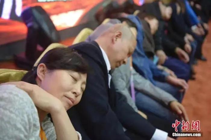 资料图:民众在专业催眠师的引导下睡觉,释放压力。中新社发 韦亮 摄